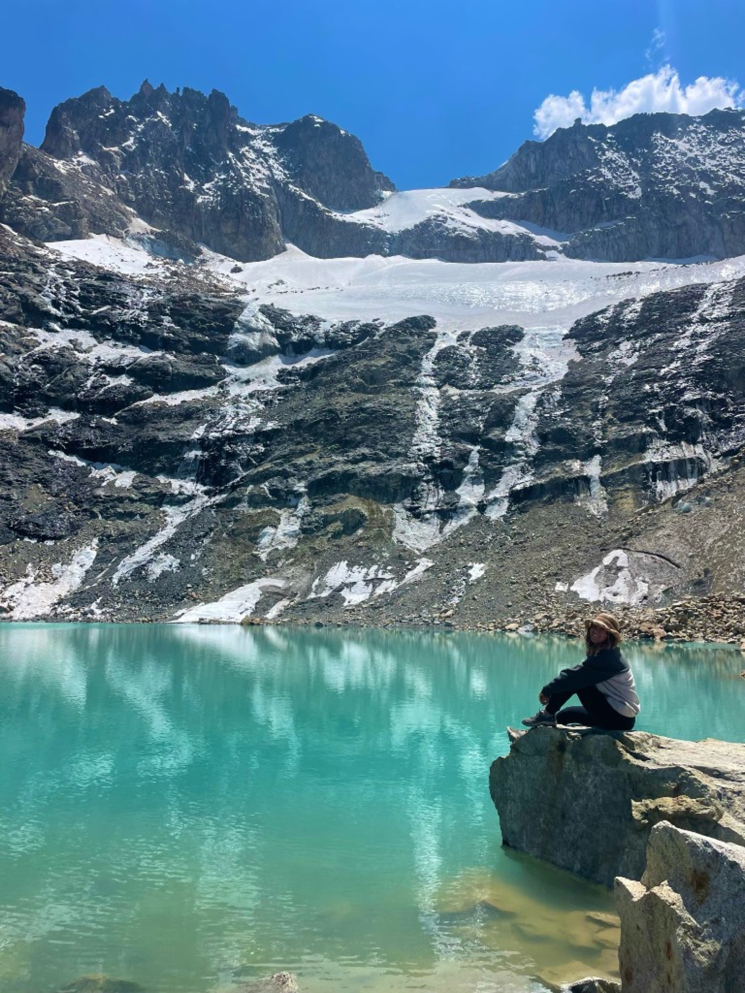 Tash beside a glacial lake in the mountains